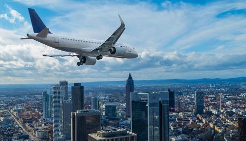 um avião está a sobrevoar uma cidade com edifícios em Müller-Luxus-Hotel em Warburg