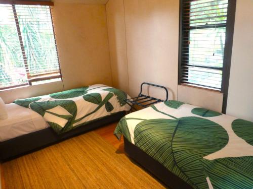 a bedroom with two beds and two windows at Park Ridge Retreat in Gerringong