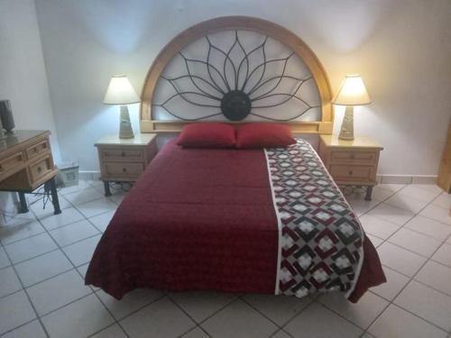 a bedroom with a large bed with a red bedspread at Colinas C12-2 in San Carlos