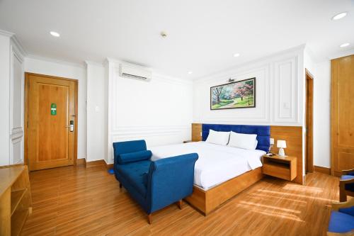 a bedroom with a bed and a blue chair at Vivian Airport Hotel Saigon in Ho Chi Minh City