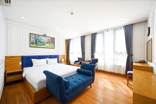 a hotel room with a bed and a blue couch at Vivian Airport Hotel Saigon in Ho Chi Minh City