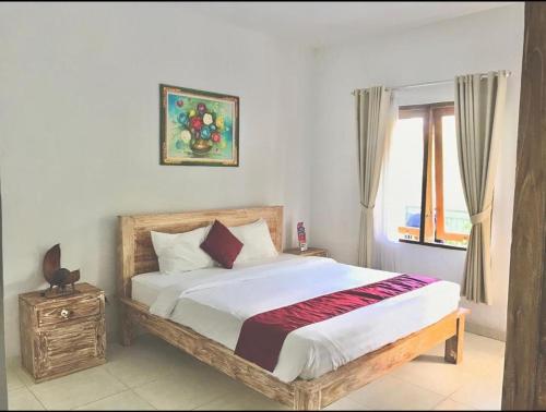 a bedroom with a large bed with a window at Double D Guest House Canggu in Canggu