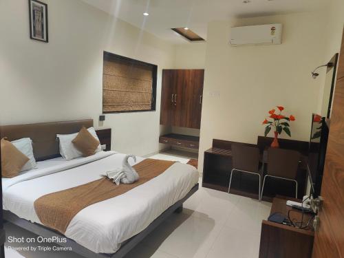 una camera da letto con un letto e un animale di peluche di HOTEL CVR a Nānded