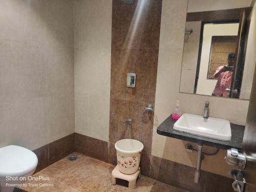 a bathroom with a sink and a toilet and a mirror at HOTEL CVR in Nānded