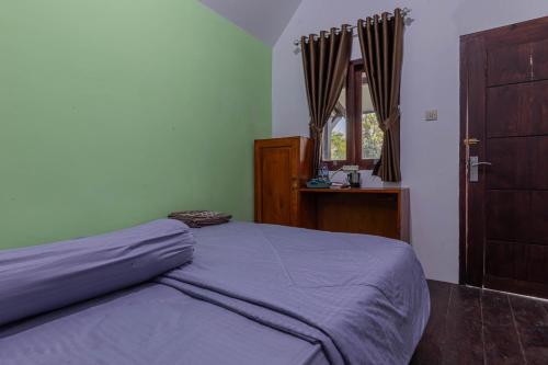 1 dormitorio con cama, ventana y puerta en Bale Gantar en Sembalunlawang