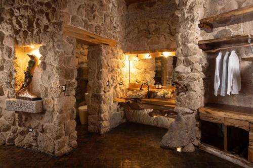 La salle de bains en pierre est pourvue d'un lavabo et d'un miroir. dans l'établissement Casa Arte, à Chimaltenango