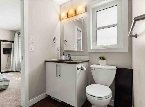a bathroom with a toilet and a sink and a window at Entire house to yourselves - NO basement sharing in Regina