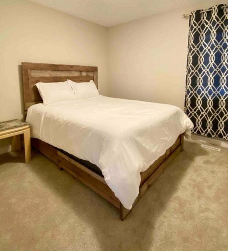 a bedroom with a large bed with white sheets at Entire house to yourselves - NO basement sharing in Regina