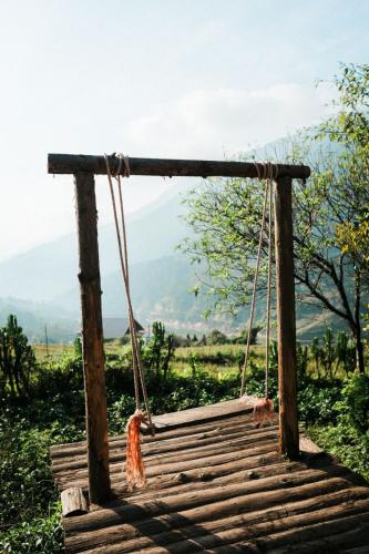 a swing in a field with mountains in the background at La Beauté Sa Pa in Sa Pa