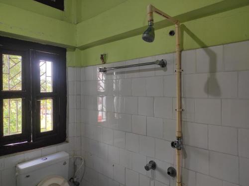 łazienka z toaletą i oknem w obiekcie Duda Lodge w mieście Tezu