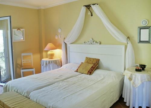 Villa Javea في خافيا: غرفة نوم بسرير أبيض مع مظلة