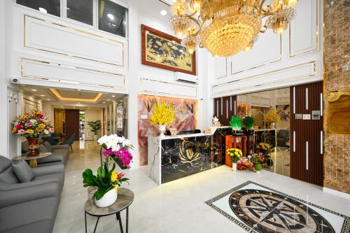 a lobby with a chandelier and flowers at Vivian Airport Hotel Saigon in Ho Chi Minh City