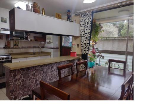 a dining room with a table and a kitchen at Puerto Perales Talcahuano in Talcahuano