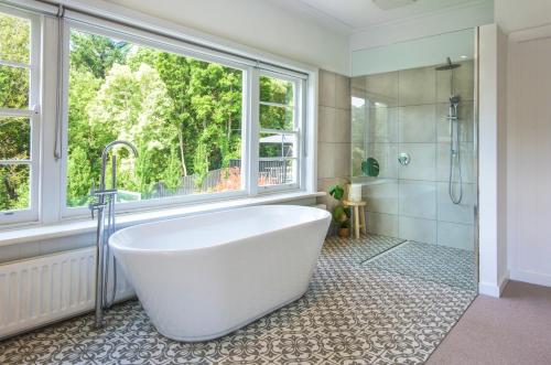a white bath tub in a bathroom with a window at Luxury Resort Style in Olinda - Greenways in Olinda