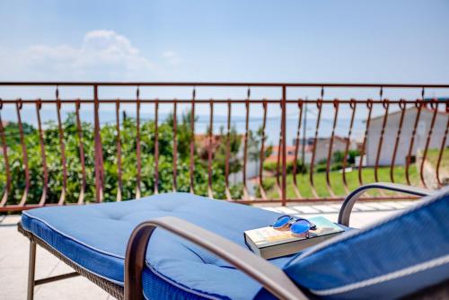 a blue chair with a book and glasses on it at Bed & Breakfast Senator in Podstrana