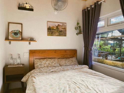 a bedroom with a bed and a window at Oak Village by D Home Da Lat in Da Lat