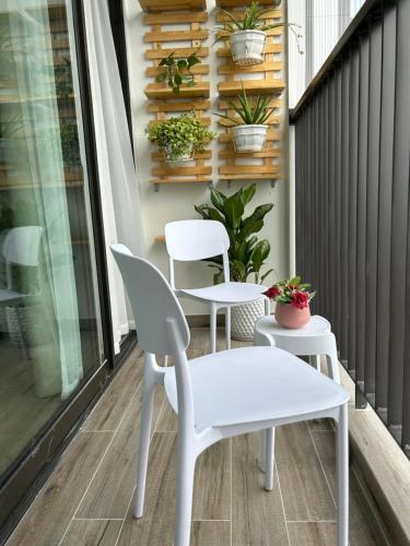 a white table and chairs on a balcony with plants at Thóc Ecopark blue home-1 bed room in Cong Luận