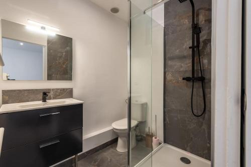 La salle de bains est pourvue d'une douche en verre et de toilettes. dans l'établissement Le Nirvana T avec salle de sport, à Rouen