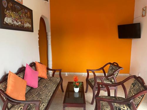 a living room with two chairs and a couch and a table at Cinnamon City in Hikkaduwa