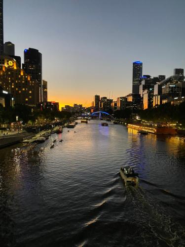 a river with boats in a city at sunset at Luxurious Apartment in the heart of Docklands in Melbourne
