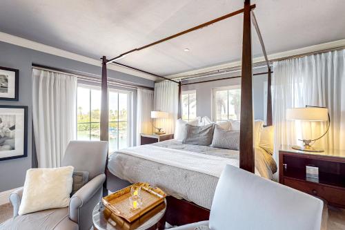 una camera con letto a baldacchino e 2 sedie di Belle Harbor Charm a Clearwater Beach