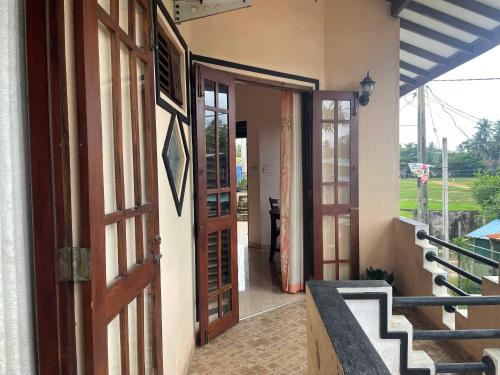 an open door to a house with a balcony at Cinnamon City in Hikkaduwa