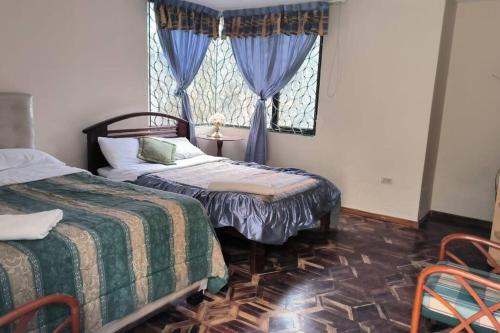 a bedroom with two beds and a window at Casa de campo centro Cotacachi. in Cotacachi