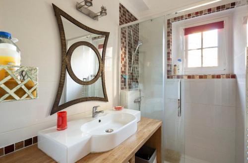 ein weißes Badezimmer mit Waschbecken und Spiegel in der Unterkunft Appartement Au Coeur D'intra Muros in Saint-Malo