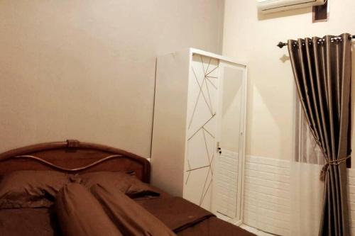 - une chambre avec un lit, une commode et un miroir dans l'établissement Florence guest house mataram lombok, à Mataram