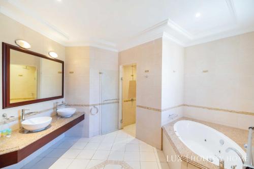 a bathroom with two sinks and a tub and a shower at LUX - The Ocean Pearl Villa in Dubai