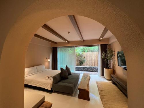 叻丕的住宿－茵拉亞拉查布里旅館，卧室配有床、椅子和窗户。