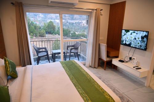 um quarto com uma cama e uma varanda com uma televisão em mountain crest em Solan