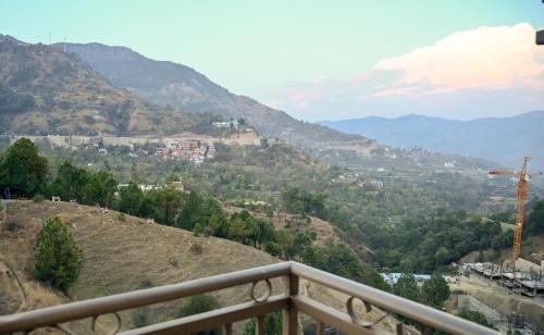 uma vista para um vale a partir de uma varanda em mountain crest em Solan
