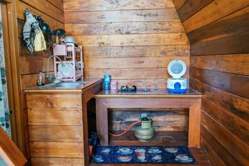 una pequeña cocina con fregadero y fregadero en Golden Orchid Villa en Dieng