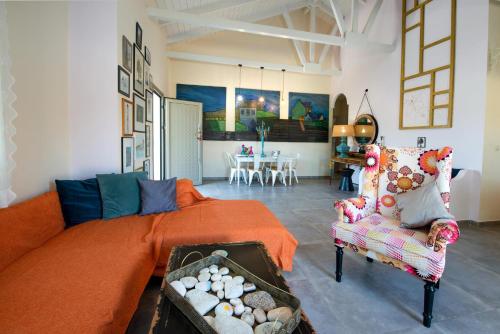a living room with an orange bed and a chair at Vasia's Artistsvillas in Gaios