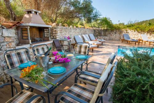 a patio with a table and chairs and a pool at Vasia's Artistsvillas in Gaios