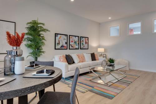 a living room with a white couch and a table at Luxurious Modern Home With King Bed & Office in Calgary