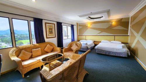 a hotel room with two beds and a couch and chairs at Fair Park Premier in Ipoh
