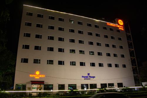 um grande edifício branco com um cartaz em Mango Grove Hotel em Chandīgarh