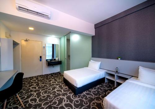 a hotel room with two beds and a bathroom at Deview Hotel Penang in Ayer Itam