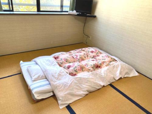 a bed in the corner of a room at Ocean View Hamayu in Makinohara
