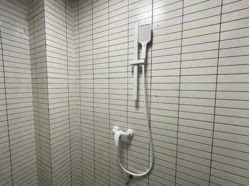 un cabezal de ducha en la pared del baño en Pomelo Hostel, en Yangshuo
