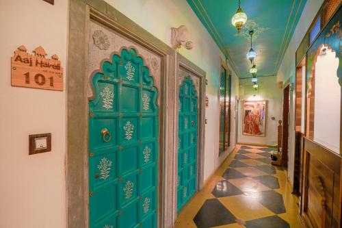 pasillo con puerta verde y suelo de baldosa en AAJ HAVELI - Pichola Lake Facing Hotel, en Udaipur