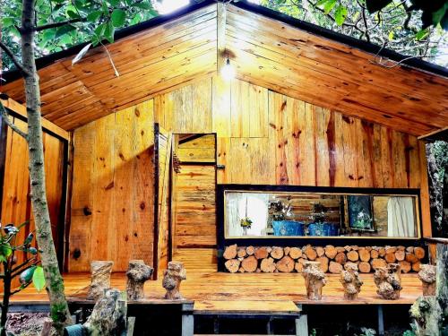 a wooden building with a bunch of logs at Homestay Vườn Trái Cây Nhiệt Đới VÔ ƯU GARDEN in Bao Loc