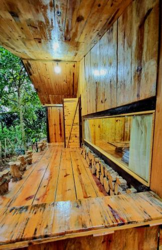 a large wooden room with a wooden floor and ceiling at Homestay Vườn Trái Cây Nhiệt Đới VÔ ƯU GARDEN in Bao Loc