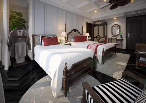 um quarto com 2 camas, uma mesa e um espelho em Hanoi Graceful Hotel and Travel em Hanói