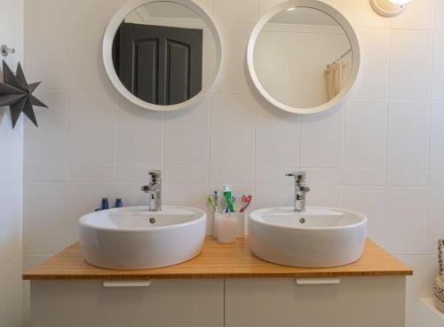 La salle de bains est pourvue de 2 lavabos et de 2 miroirs. dans l'établissement Lovely holiday residence with a delicious pool, à Malaga