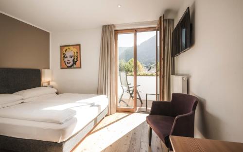 a hotel room with a bed and a window at B&B Villa Angelino in Ortisei
