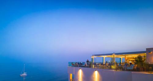 a building with a view of the ocean at night at El Fuerte Marbella in Marbella