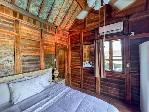 a bedroom with a bed in a wooden cabin at Melasti Mountain Villas, Amed, Room 3 Agung Guesthouse in Amed